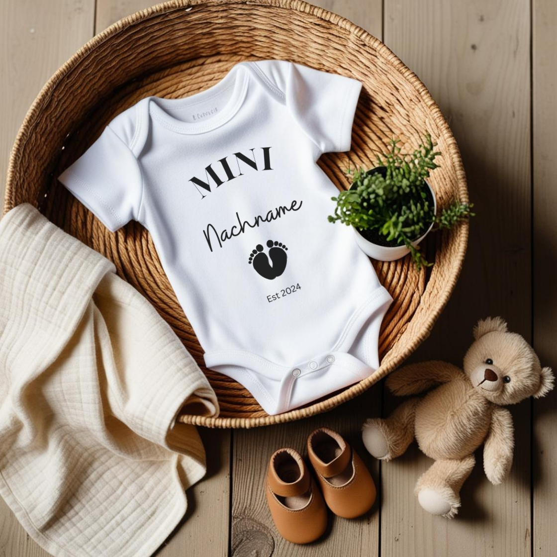 Baby Langarmshirt zur Schwangerschaftsverkündung - Mini Nachname Est. 2025